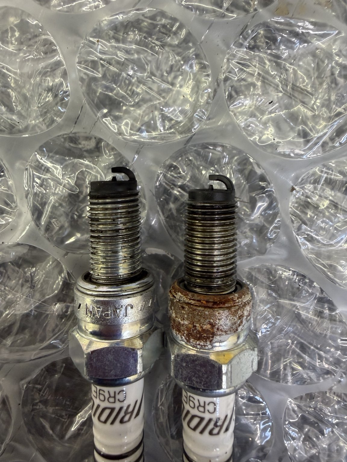 Two removed Iridium CR9E spark plugs from Suzuki TL1000R